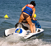 Woman rides on back of Jetski in the Mediterranean Sea
